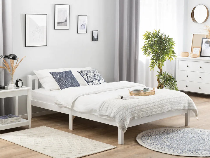 White bedroom with a bed, nightstands, and decor elements.