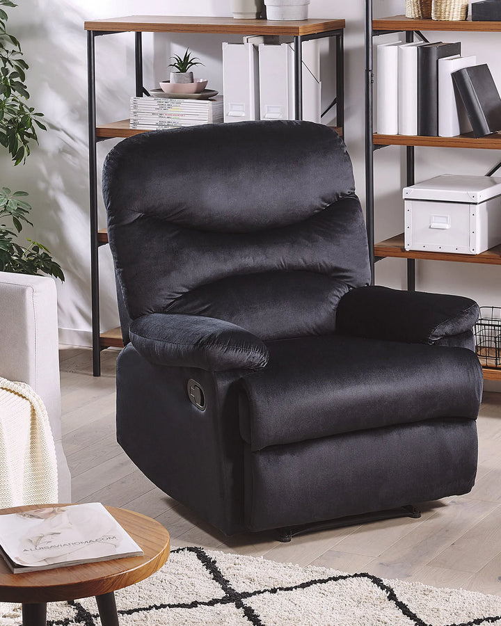 Black recliner chair in a living room setting with shelves and decor.