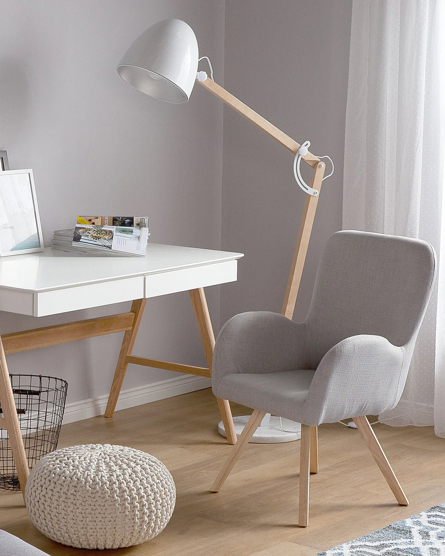 Modern home office with a desk, lamp, chair, and pouf.