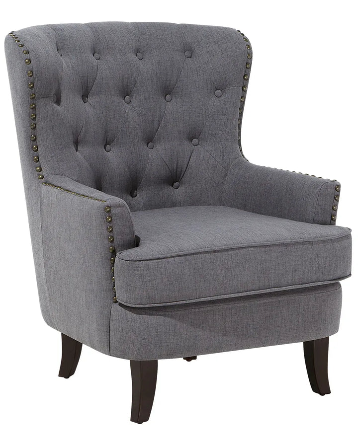 Gray upholstered chair with tufted backrest and nailhead trim on a white background