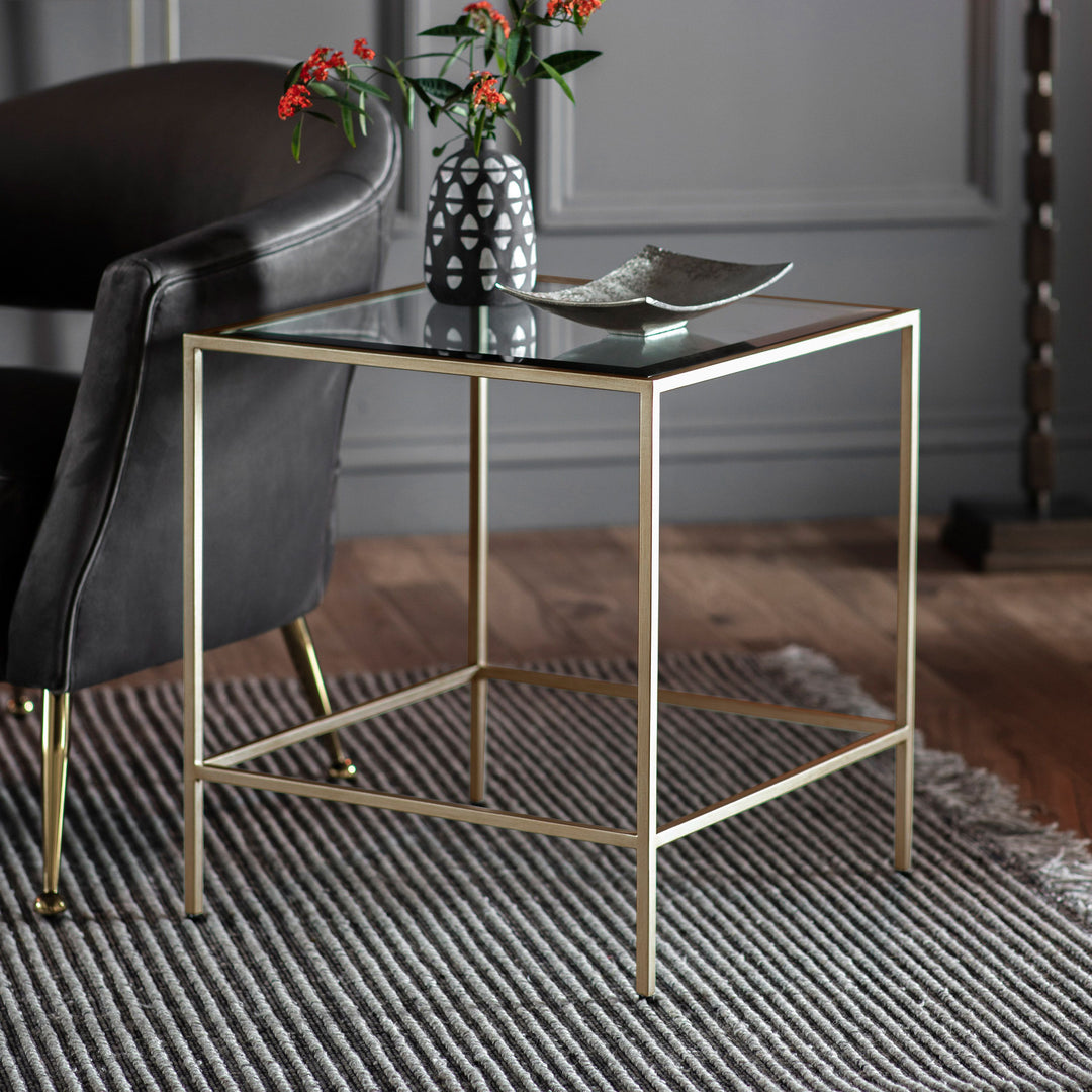 Gold side table with glass top in a room setting