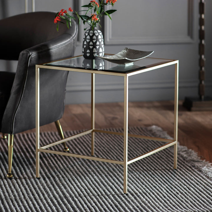 Gold side table with glass top in a room setting