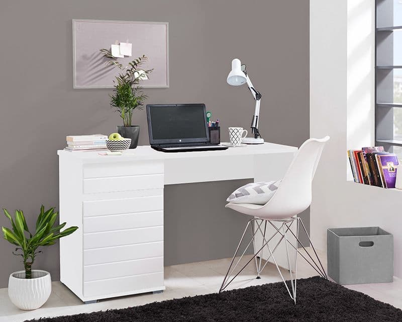 A modern white home office desk setup featuring a white desk with drawers, a white molded chair, a black laptop, a white desk lamp, and decorative plants against a gray wall.