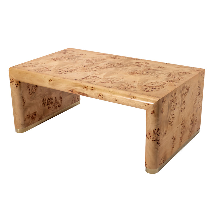 A rectangular coffee table made of natural burl wood with prominent wavy grain patterns in shades of tan, beige, and brown, featuring a thick apron base and small metallic brass-colored feet.