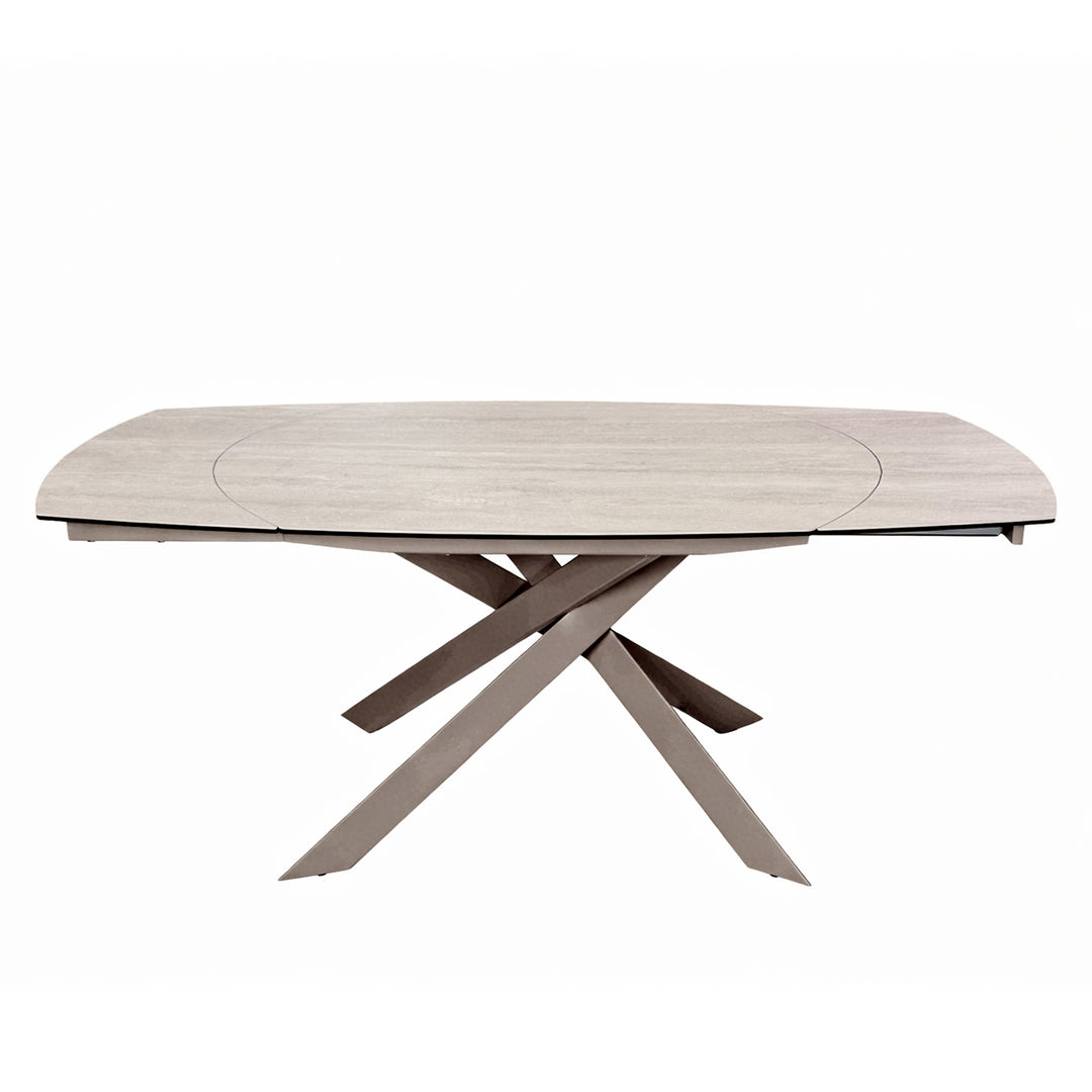 A modern oval dining table with a light beige wood-grain top and a dark brown geometric cross-style base, shown on a solid white background.