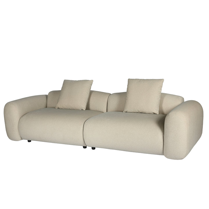 Beige sofa with two cushions on a white background