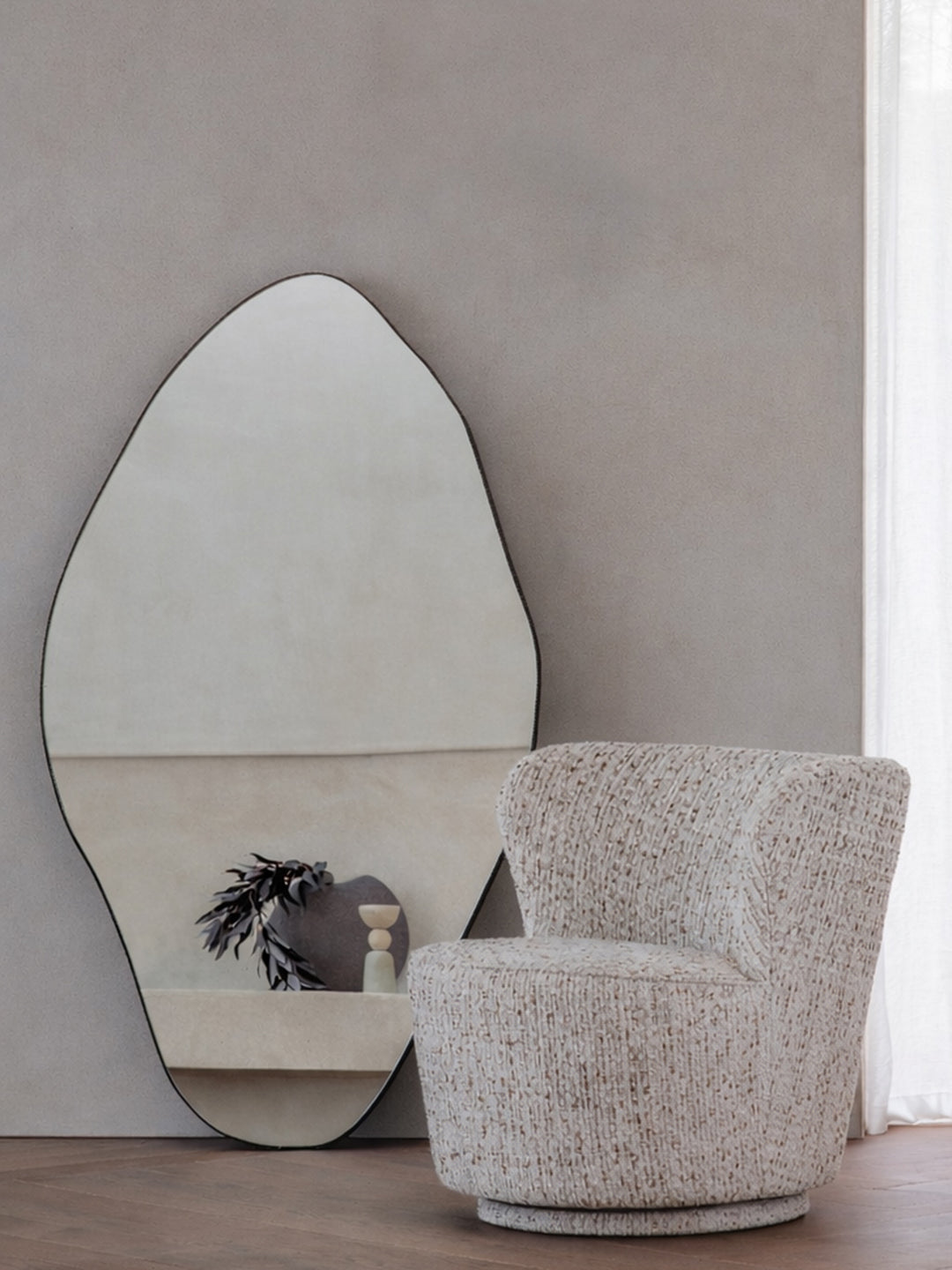 Modern chair and mirror against a neutral wall