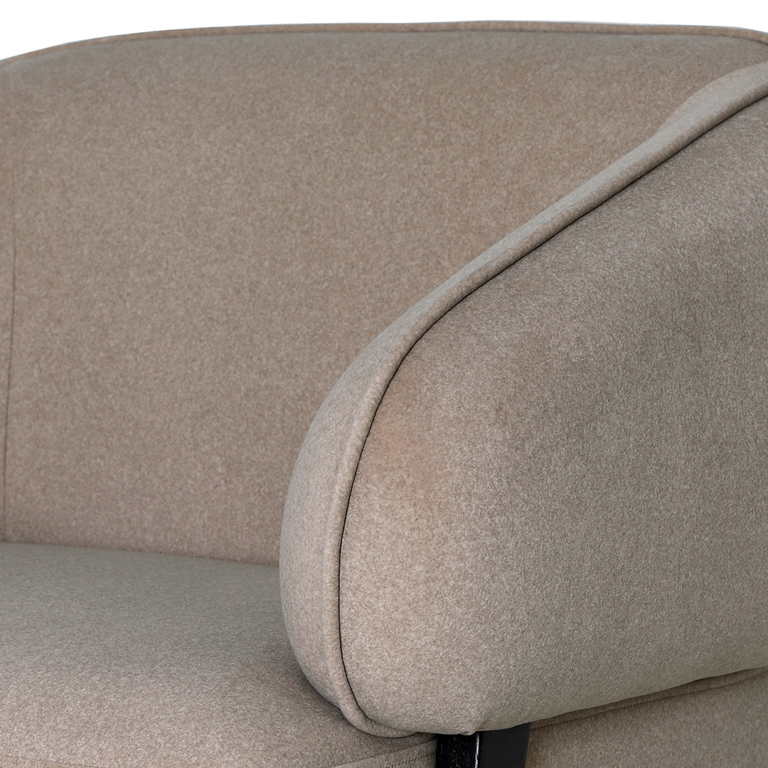 Close-up of a beige upholstered chair with a focus on the fabric texture.
