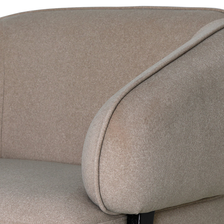 Close-up of a beige upholstered chair with a focus on the fabric texture.