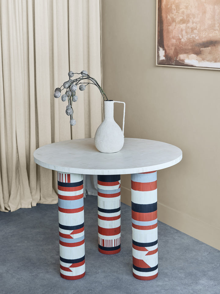 Round table with striped legs in a room setting