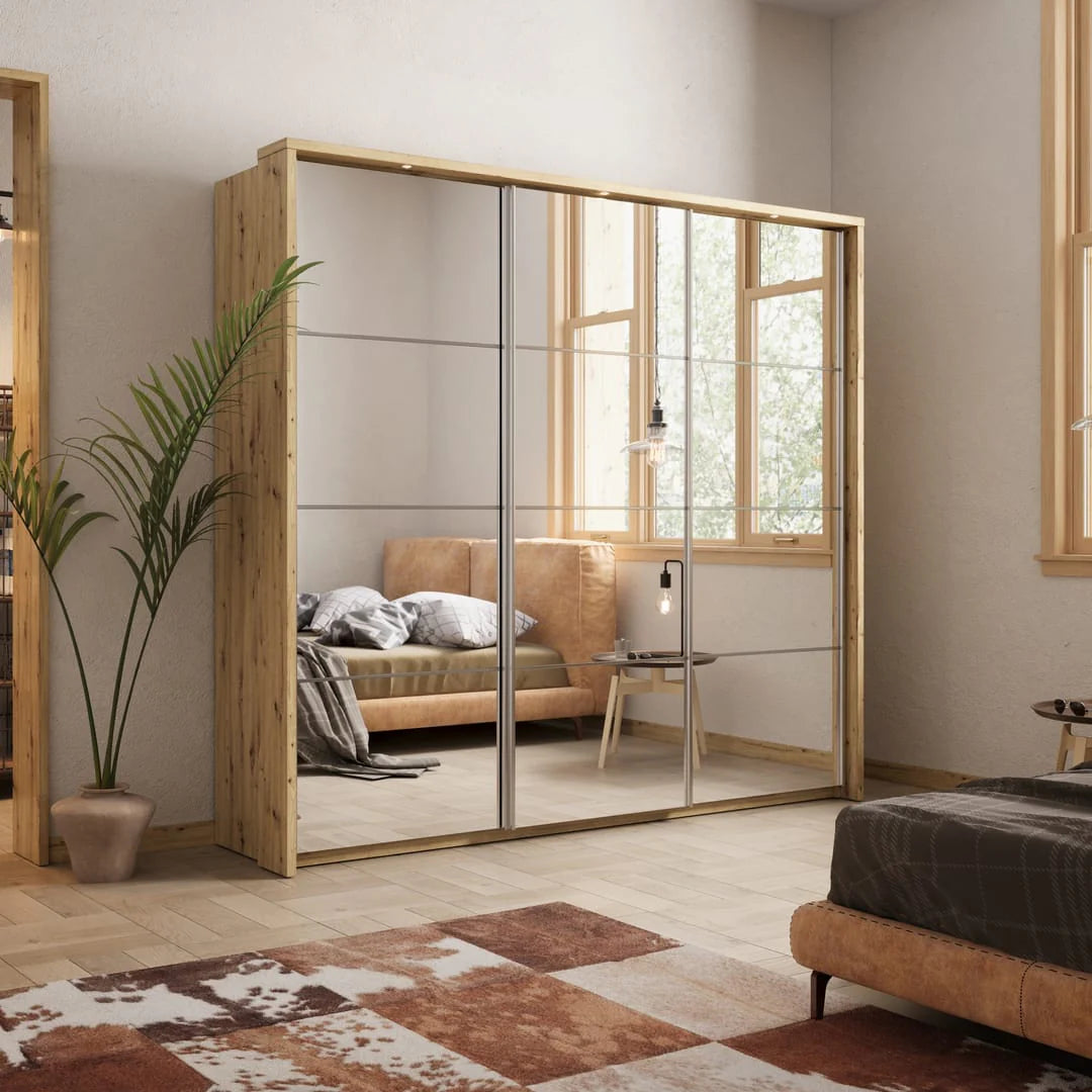 Modern bedroom with a large wooden wardrobe with glass doors, a bed, and a plant.