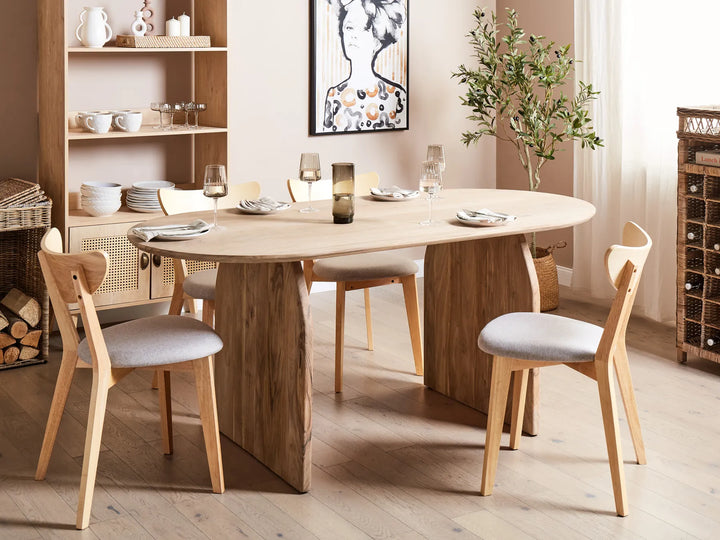 Dining room with wooden table and chairs, bookshelf, and decorative items.