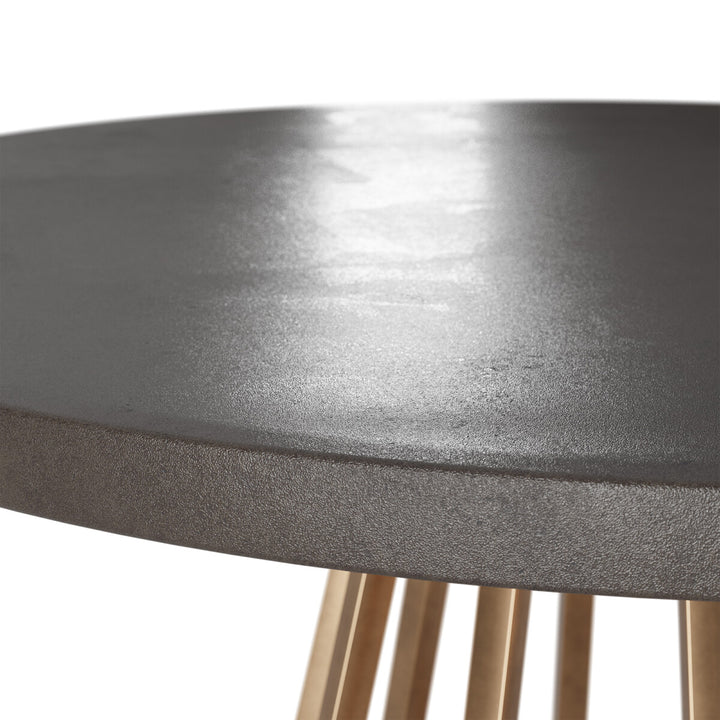 Close-up of a round metal table with a textured surface and wooden legs on a white background