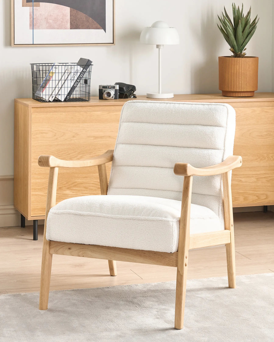 White armchair with wooden frame in a room with a wooden cabinet and decor items.