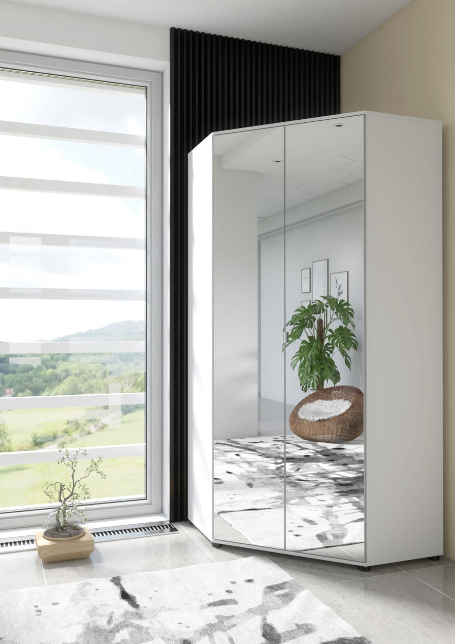 White corner wardrobe with mirror panels in a room with a large window and plants.