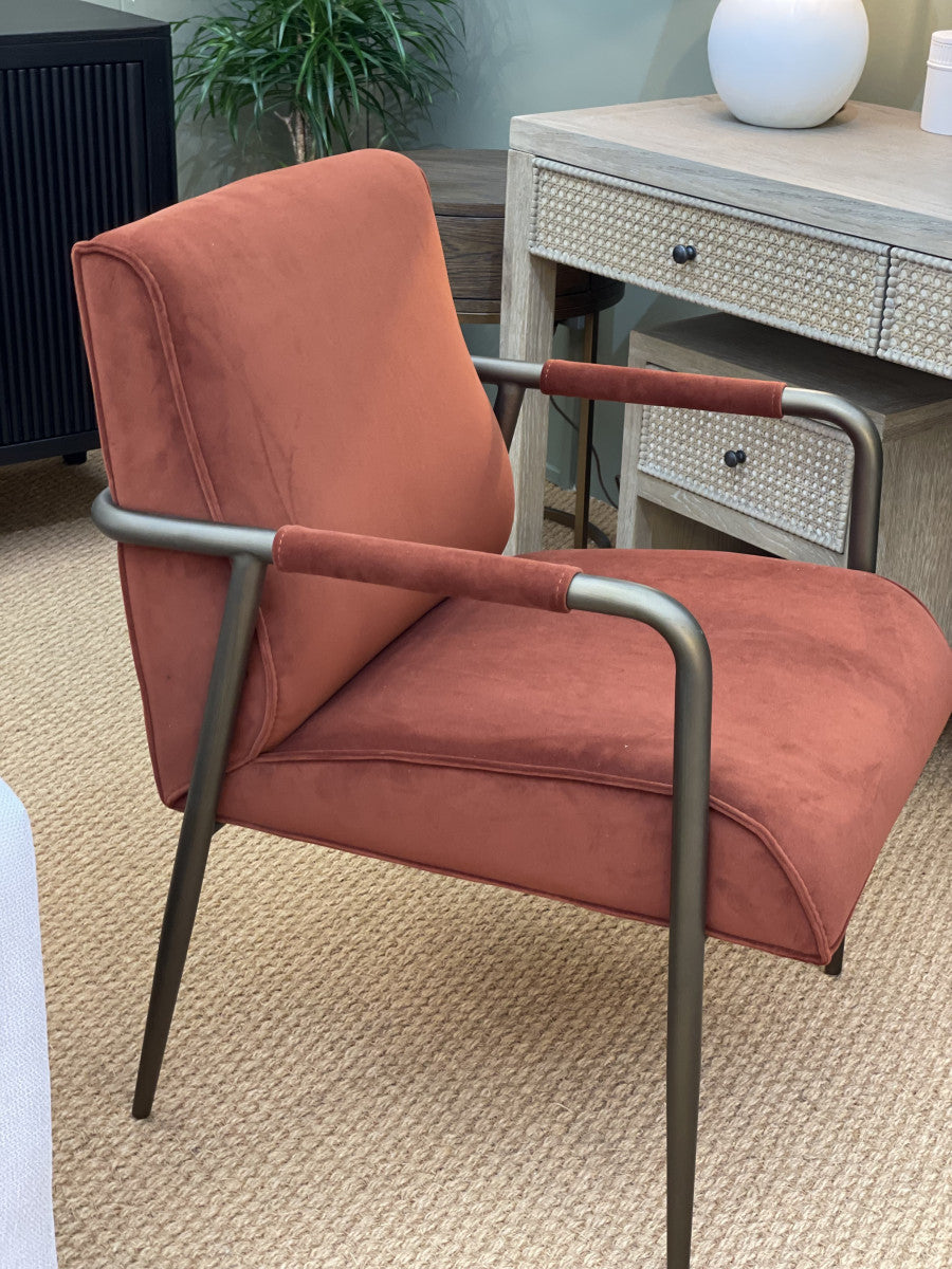 Orange armchair with metal frame on a beige carpet