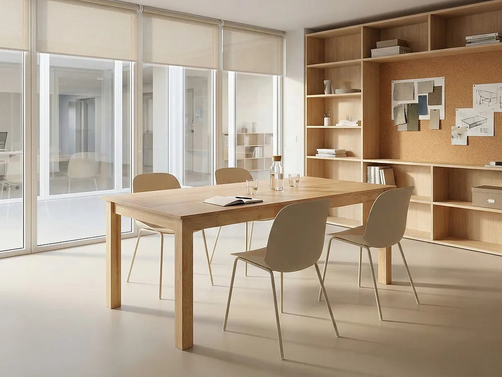 A modern dining table and four matching chairs in a minimalist, warm-toned office or dining room setting with large windows and built-in wooden shelving.