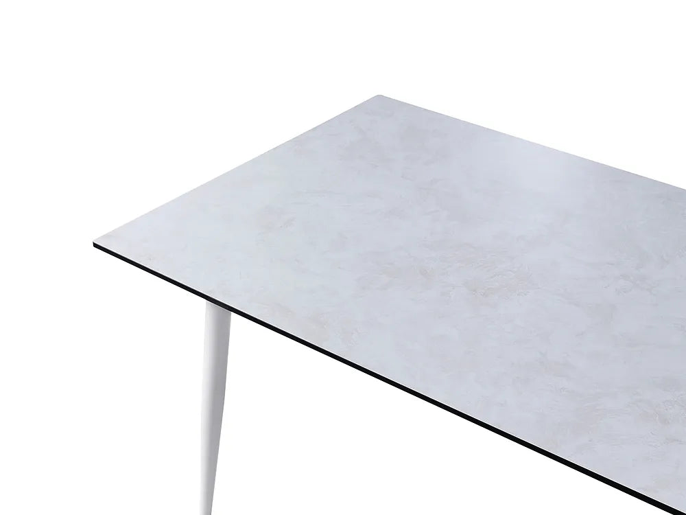 A close-up of a rectangular table top with a light gray marble or stone-look surface and a thin black edge, supported by a white leg against a white background.