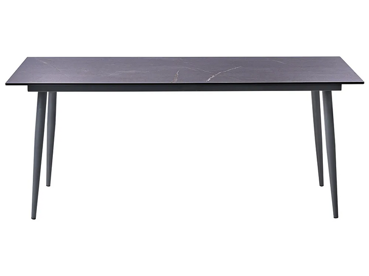 A modern rectangular dining table with a dark charcoal gray stone-look top and slim tapered legs, shown against a plain white background.