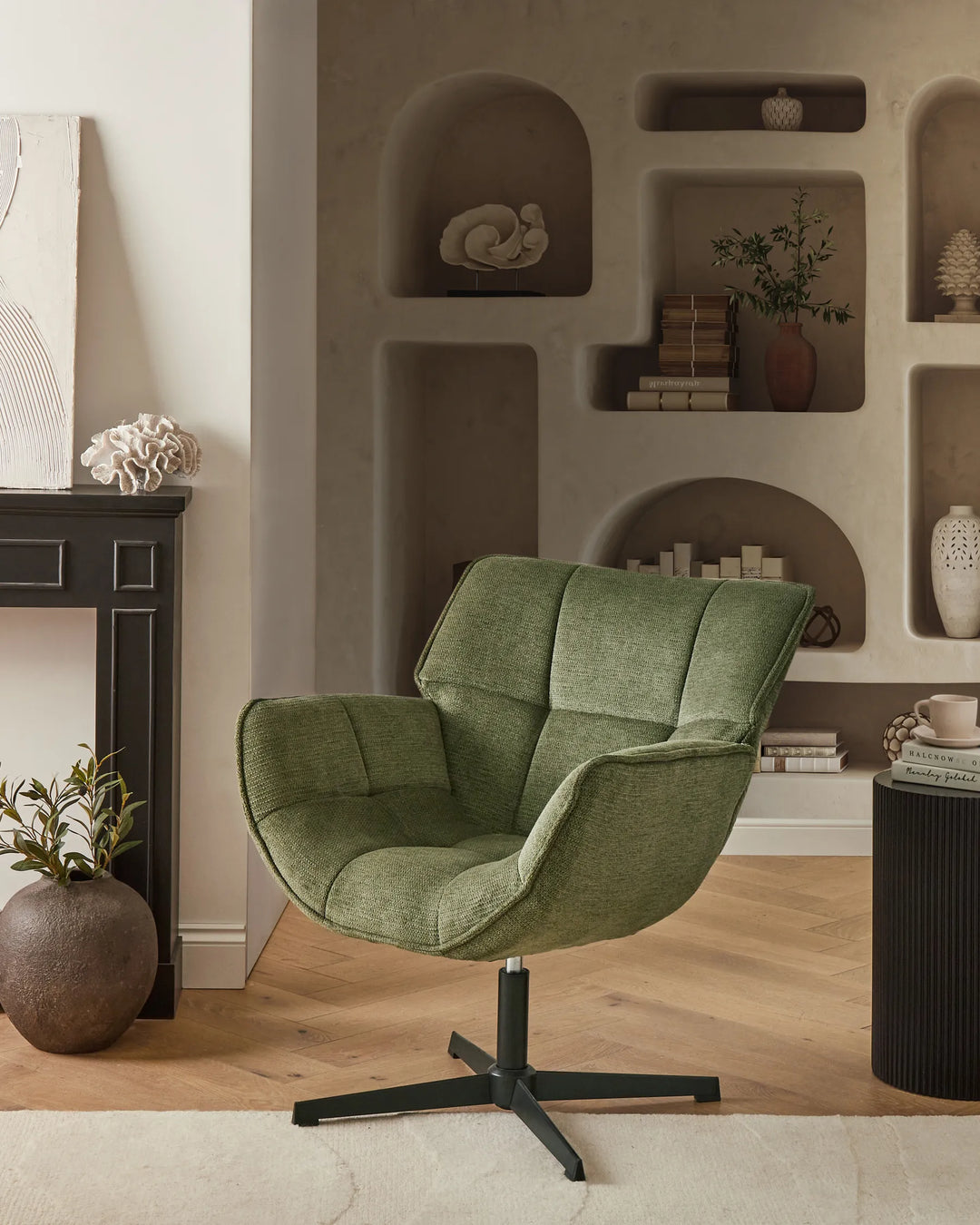 Green armchair in a living room with shelves and decor