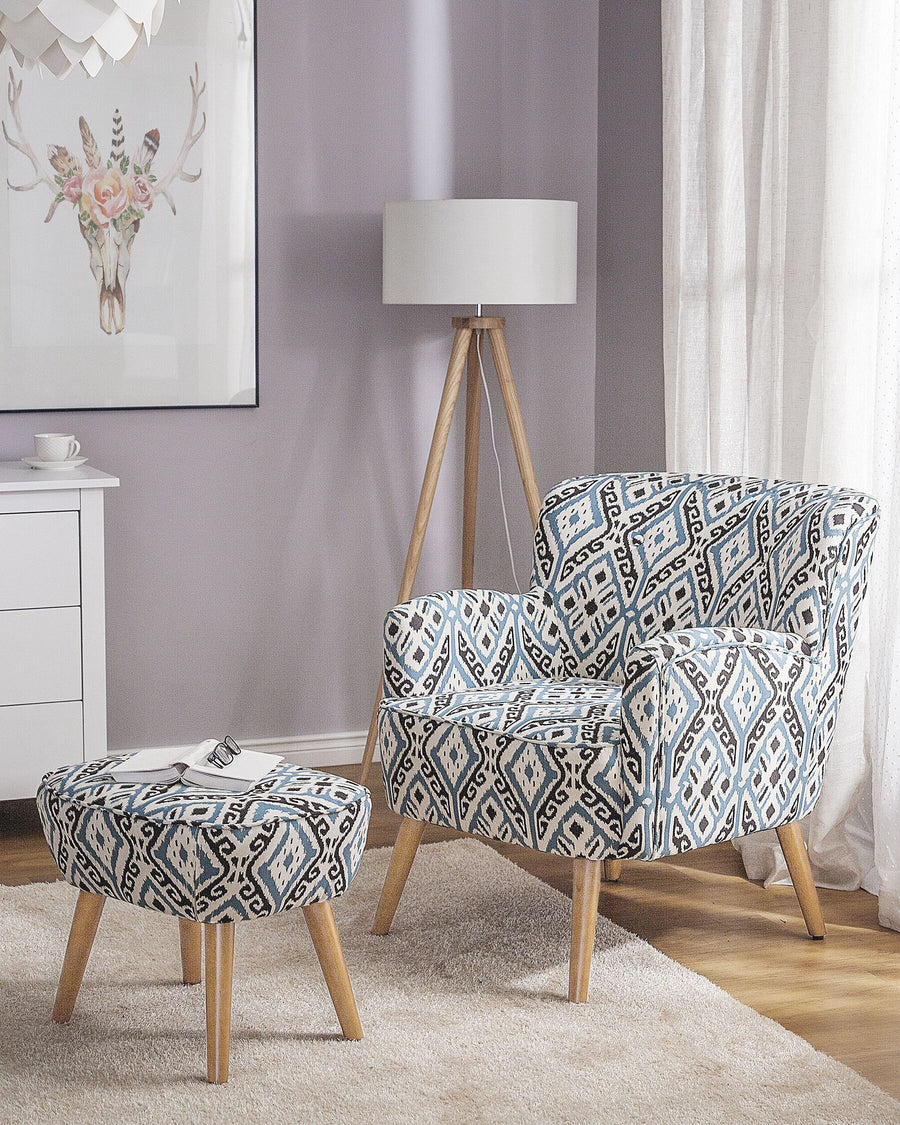 Patterned armchair and ottoman in a room with a lamp and decor.