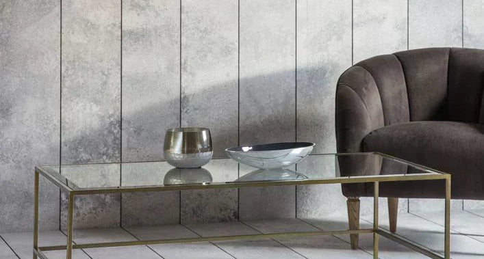 Glass coffee table with gold frame in a modern living room setting