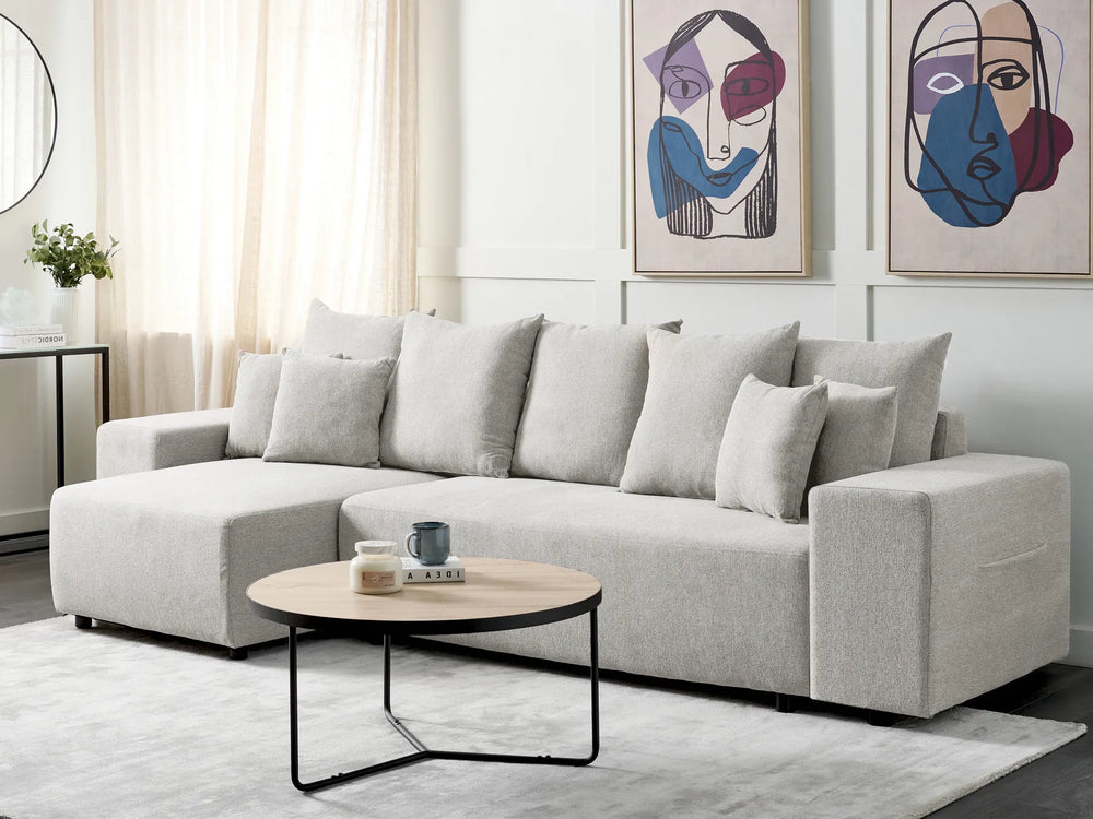 Gray sectional sofa in a living room with abstract art on the wall.