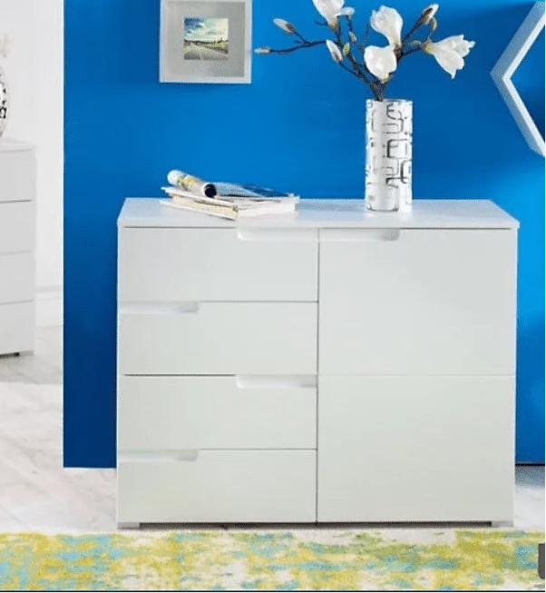 White dresser with decorative items against a blue wall