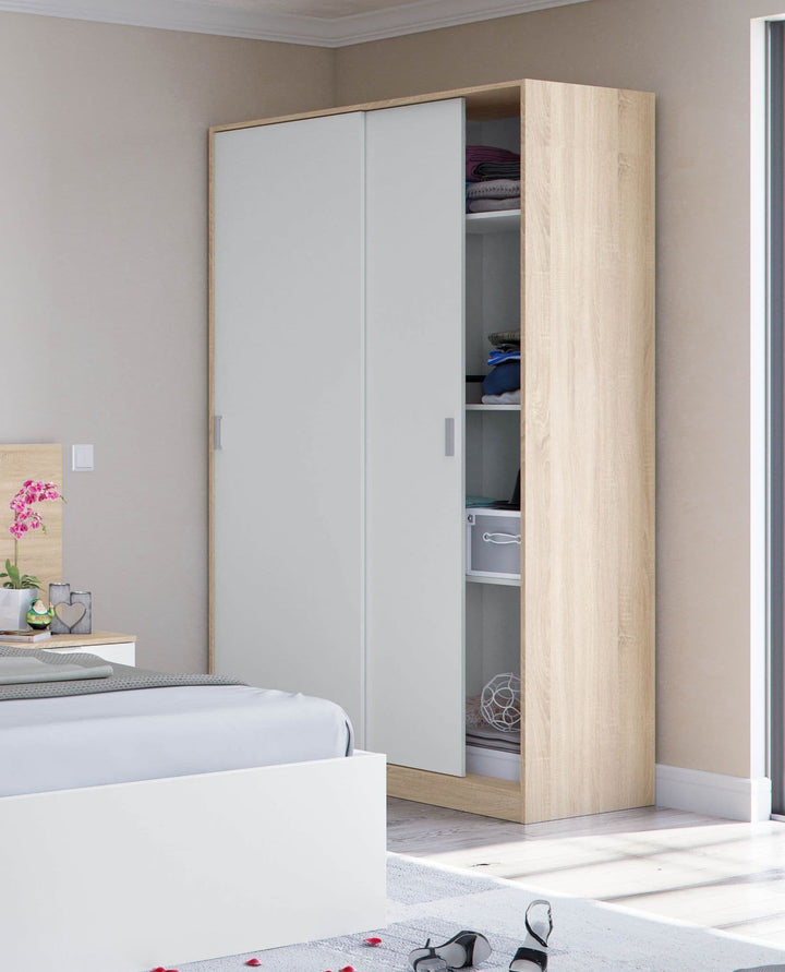 Wooden wardrobe with white sliding doors in a bedroom setting