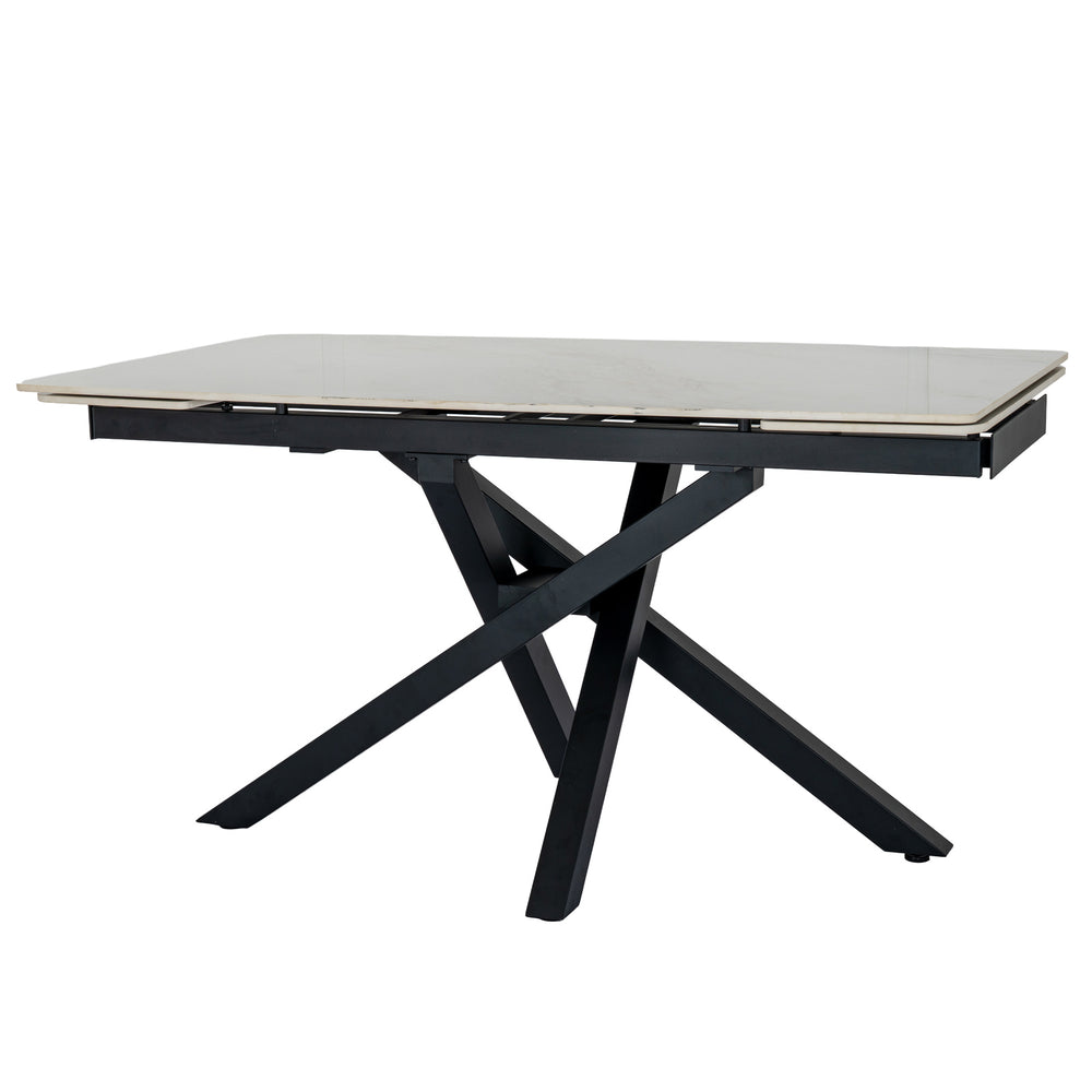 A modern rectangular dining table with a light beige stone or laminate top and a black metal frame featuring an X-shaped base, shown on a plain white background.
