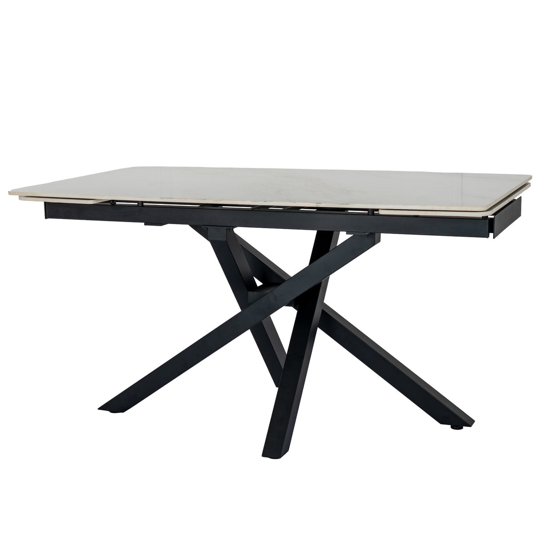 A modern rectangular dining table with a light beige stone or laminate top and a black metal frame featuring an X-shaped base, shown on a plain white background.