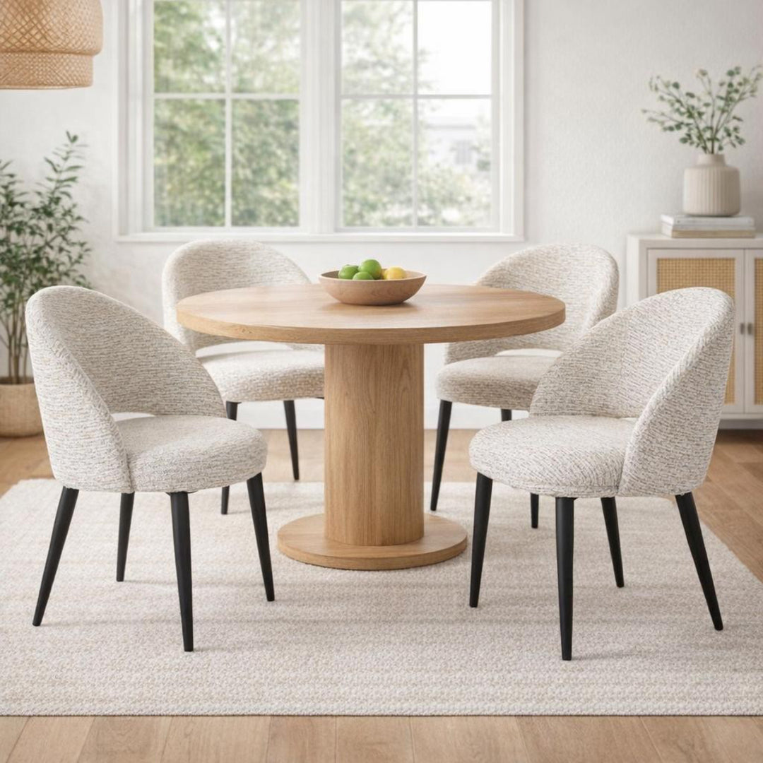 Dining room with a round wooden table and four upholstered chairs.