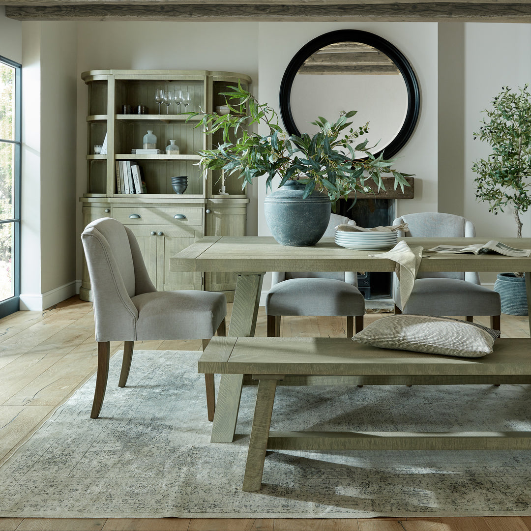 Dining room with wooden table, chairs, and a large mirror on the wall.