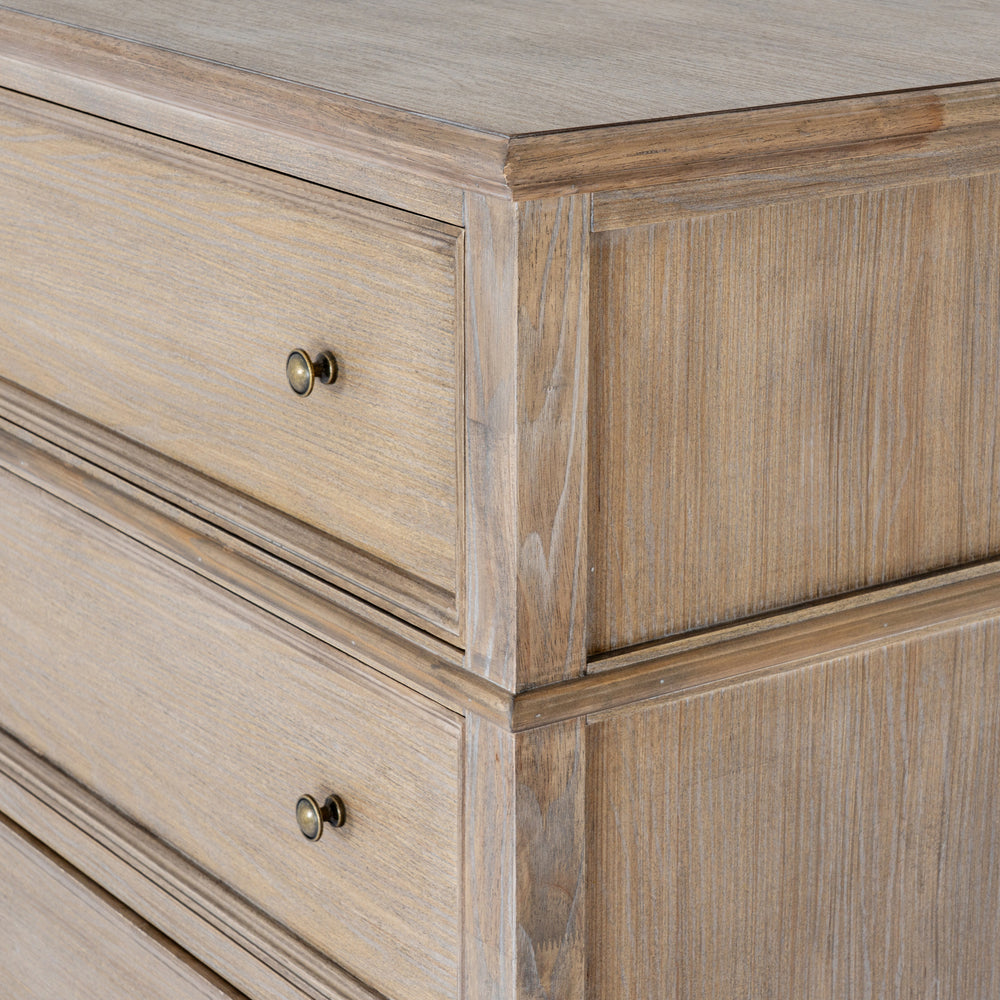 Close-up of a rustic light brown wooden dresser with two drawers featuring round brass knobs, showcasing detailed wood grain and paneling.