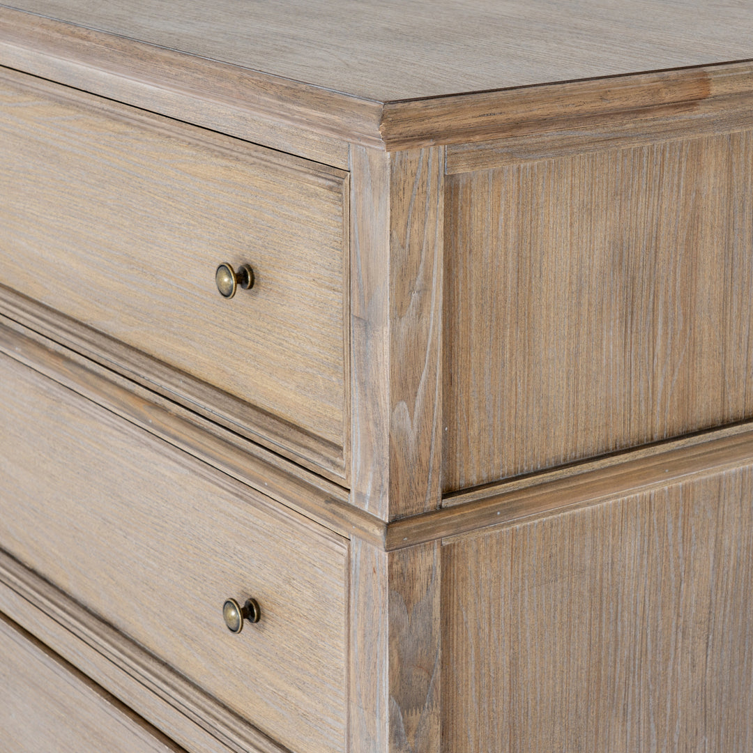 Close-up of a rustic light brown wooden dresser with two drawers featuring round brass knobs, showcasing detailed wood grain and paneling.