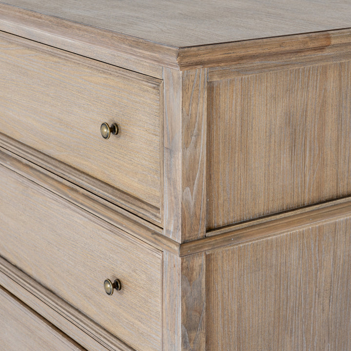 Close-up of a rustic light brown wooden dresser with two drawers featuring round brass knobs, showcasing detailed wood grain and paneling.