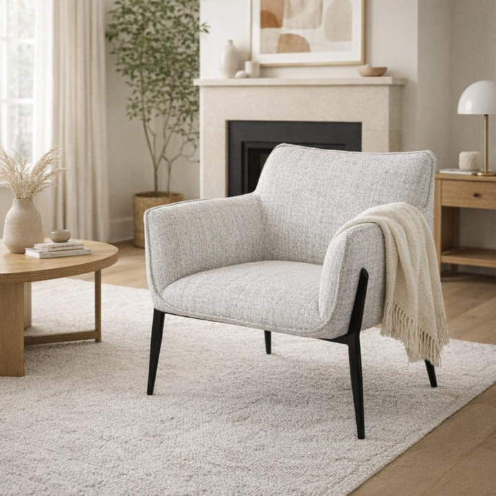 Gray armchair in a living room with a fireplace and decor elements.