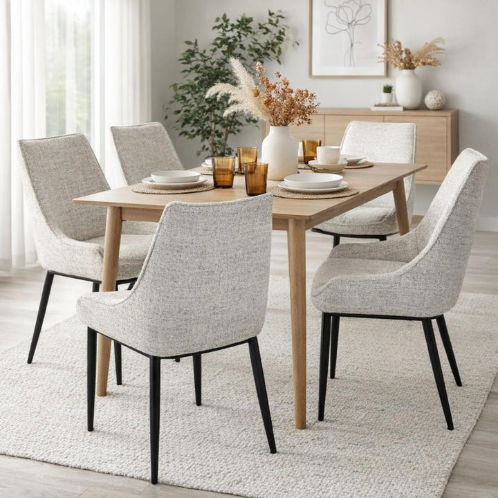 Dining room with a wooden table and gray chairs on a light rug.