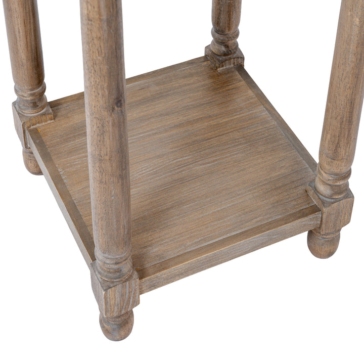 Close-up of a rustic wooden side table or stand with turned legs and a lower shelf, shown on a plain white background.