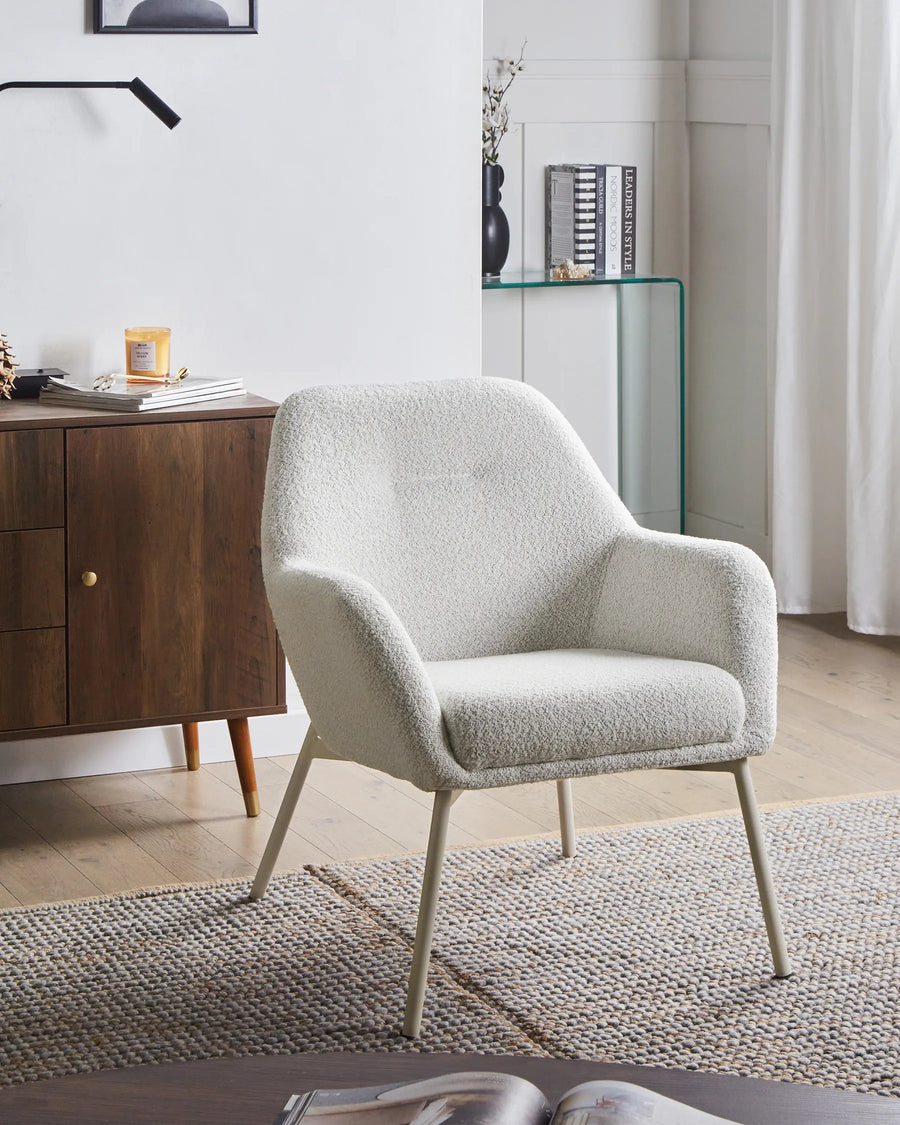 White armchair in a modern living room setting with wooden cabinet and glass shelf.