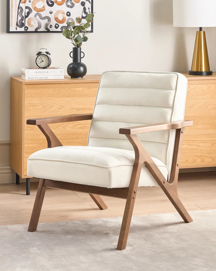 White armchair with wooden frame in a room with a dresser and decorative items.