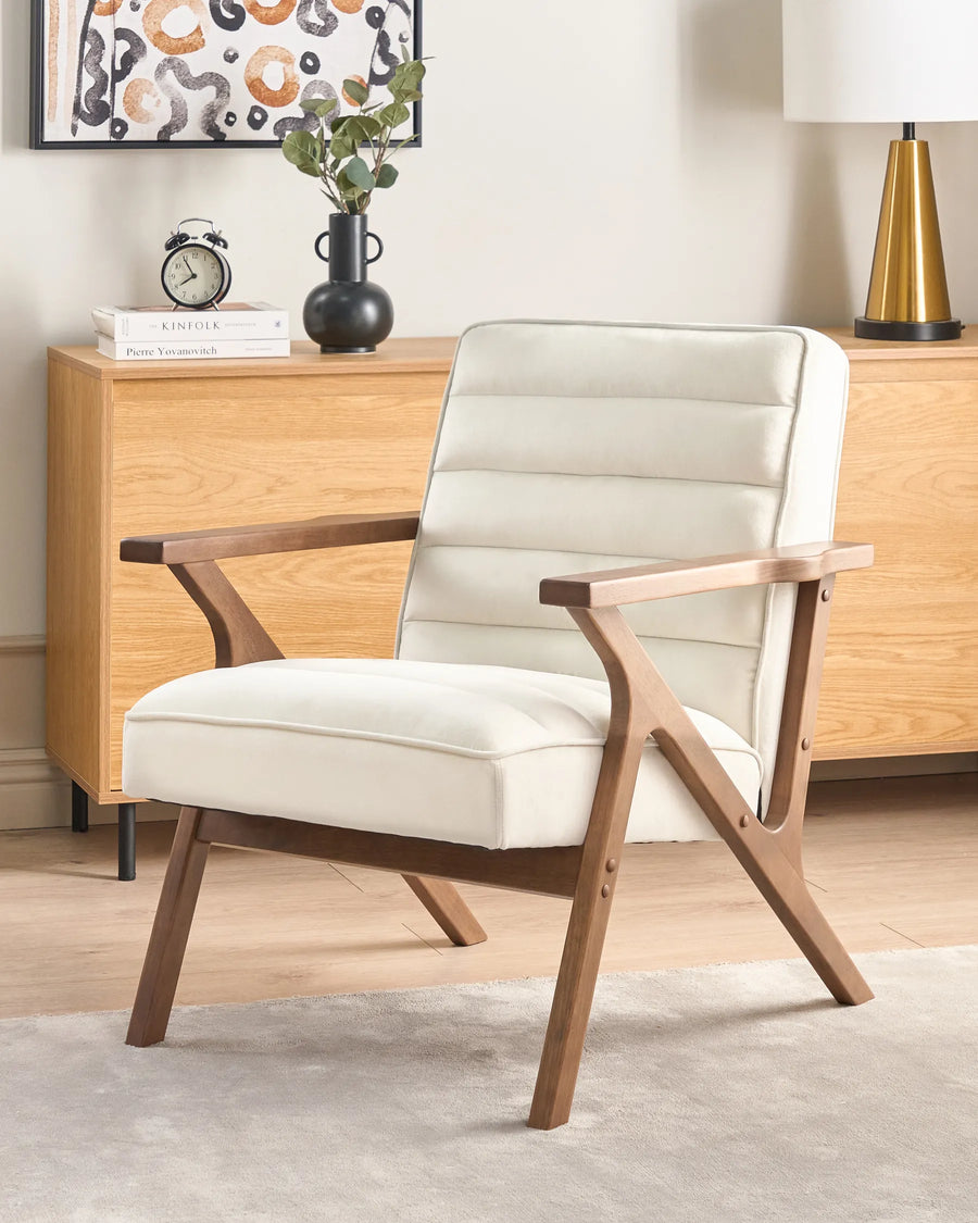 White armchair with wooden frame in a room with a dresser and decorative items.