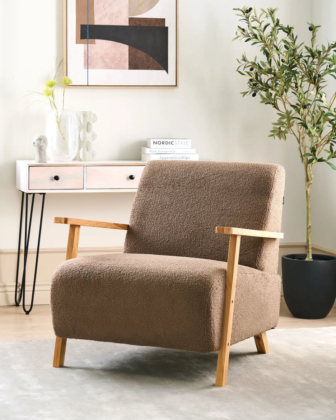 Brown armchair in a room with a side table, books, and a plant.