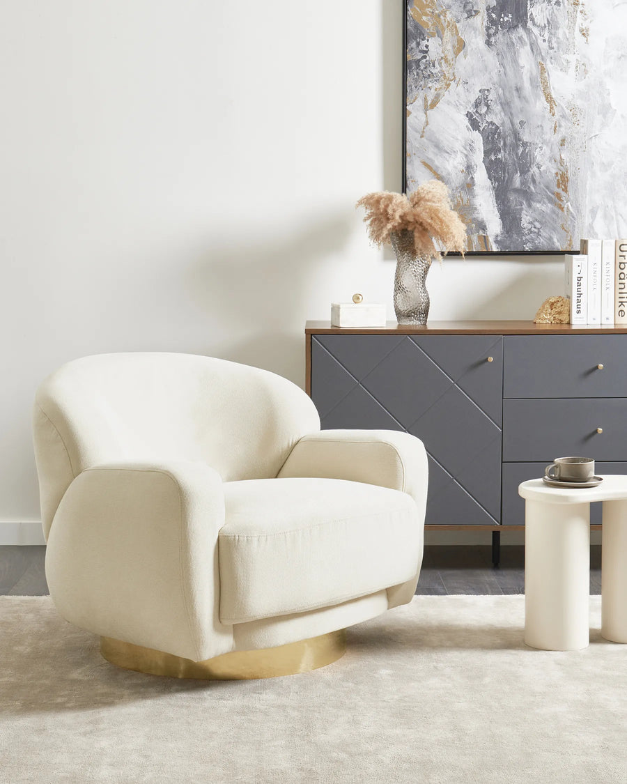Beige armchair in a living room with a gray sideboard and abstract art on the wall.