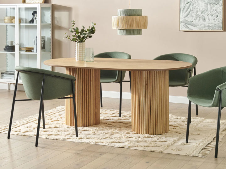 Dining room with a wooden table and green chairs on a beige rug.