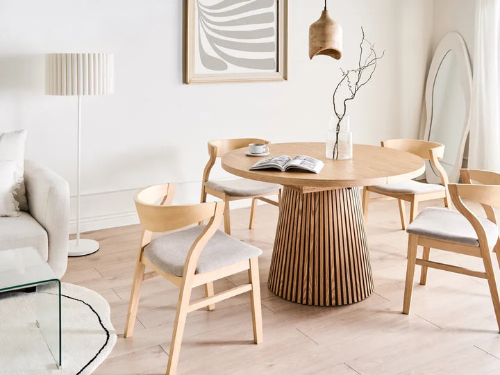 Dining area with wooden table and chairs in a modern living room.