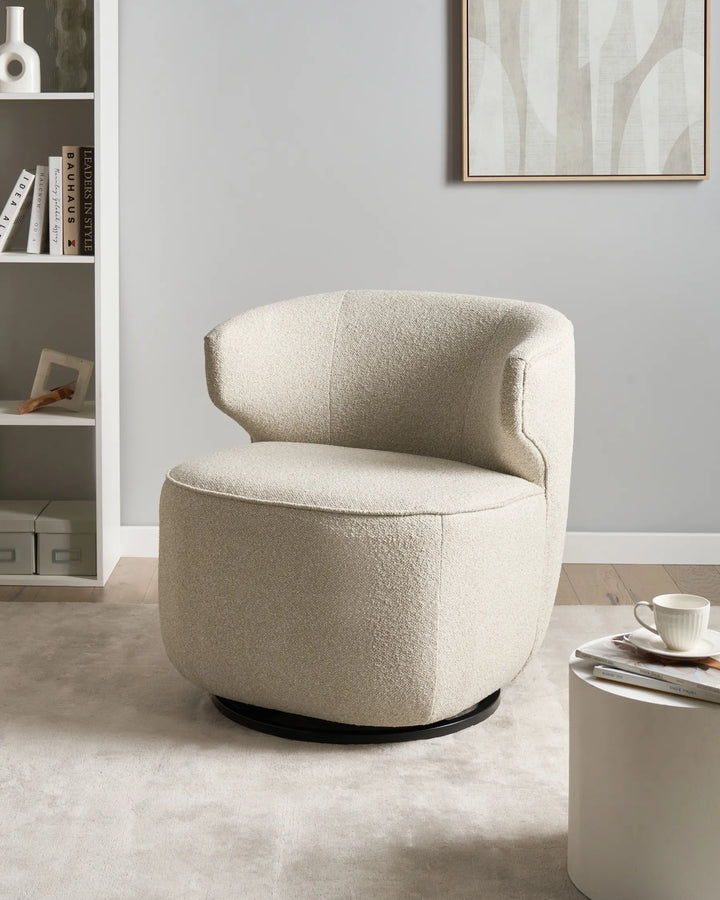 Beige armchair in a room with a bookshelf and coffee table.