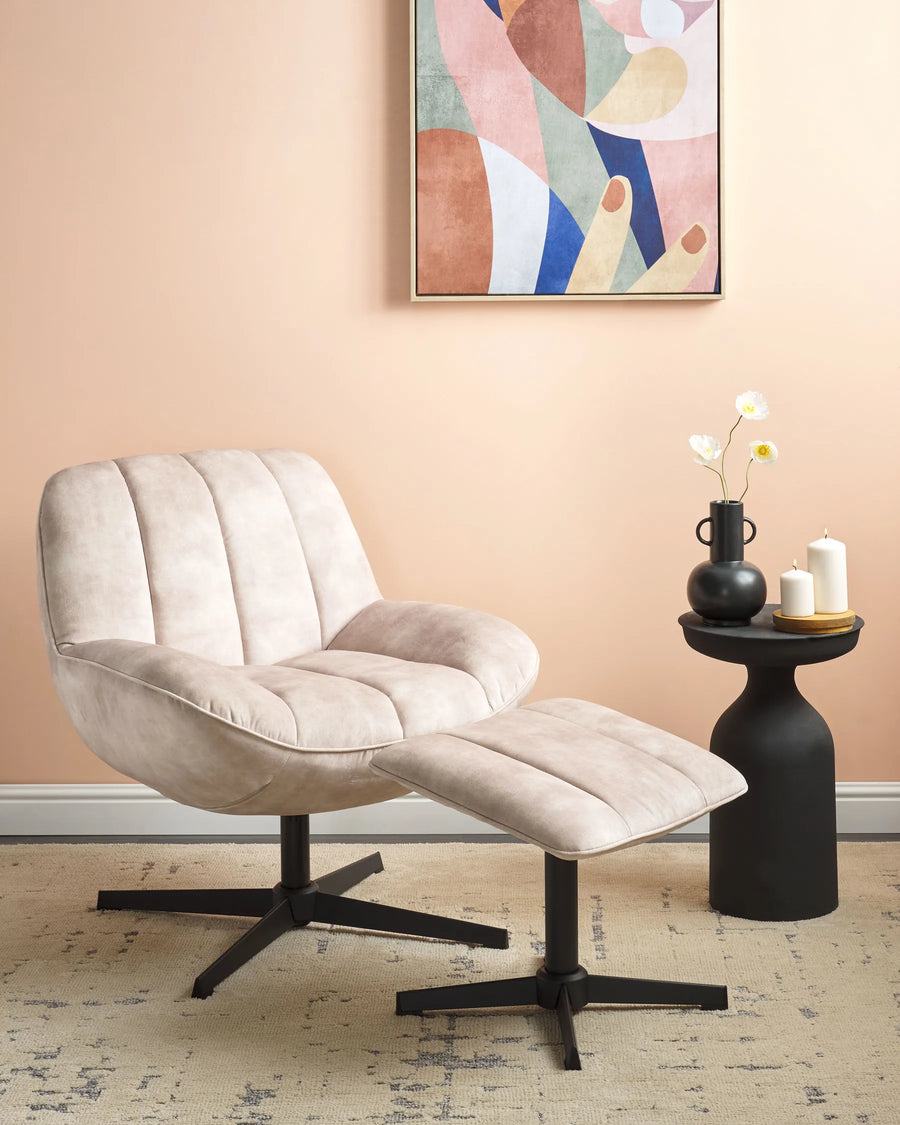 Beige armchair with ottoman in a room with a colorful abstract painting on the wall.