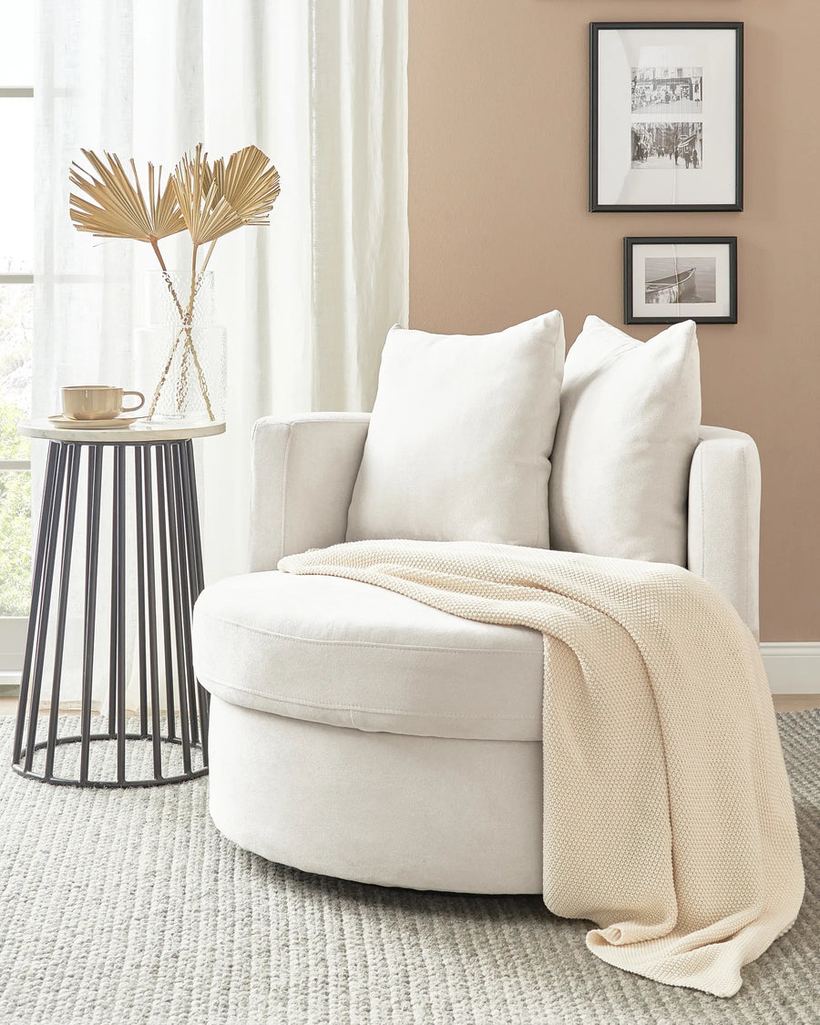 White armchair with a beige blanket in a living room setting