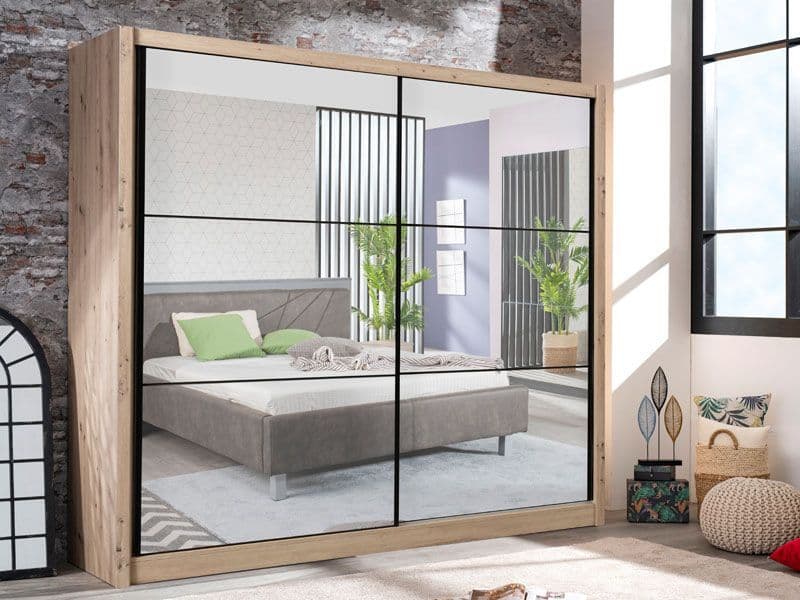 Sliding wardrobe with glass panels showing a bedroom interior.